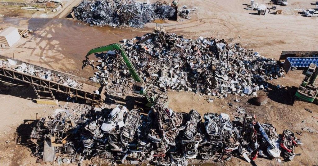 Industrial scrapyard with piles of metal and a hydraulic crane in Chattanooga, Tennessee.