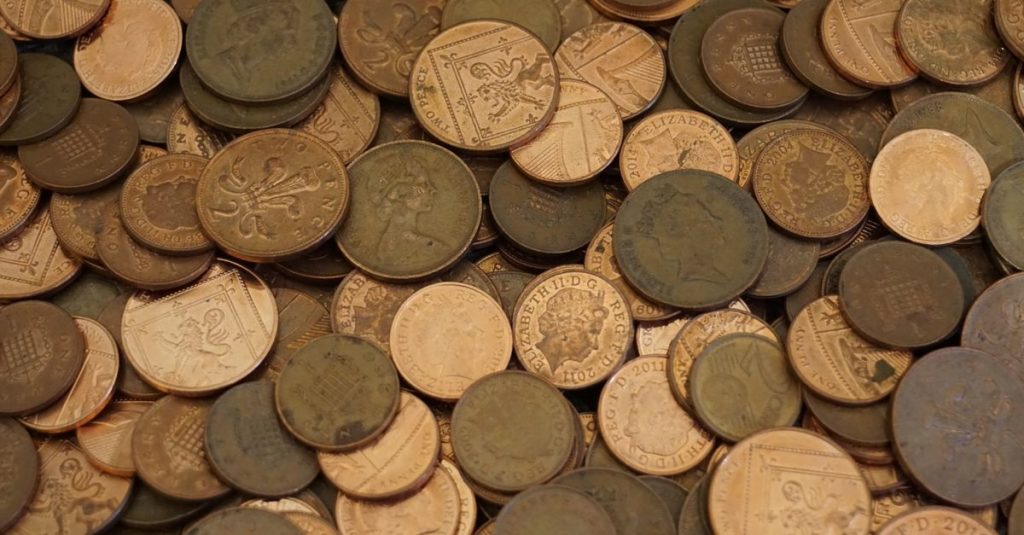 An assortment of vintage coins in varying colors and designs, showcasing historical currency.
