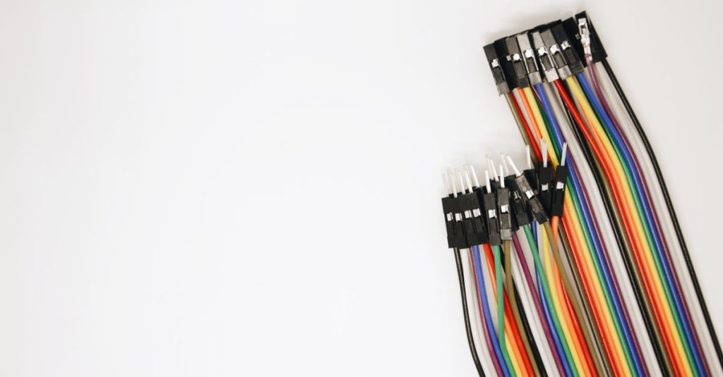 A set of colorful rainbow electrical jumper wires laid out on a white background.