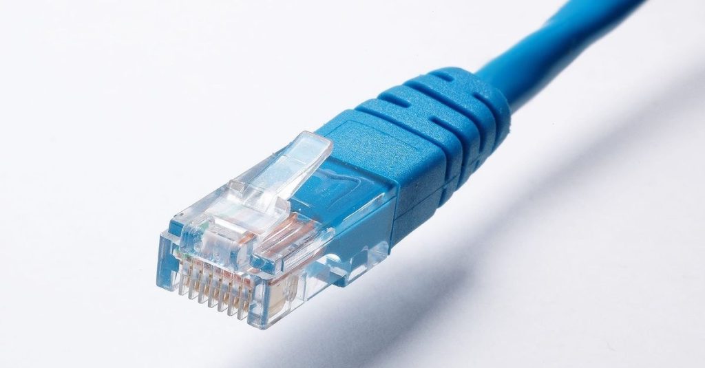 High-quality image of a blue Ethernet cable plug on a white background, ideal for tech themes.