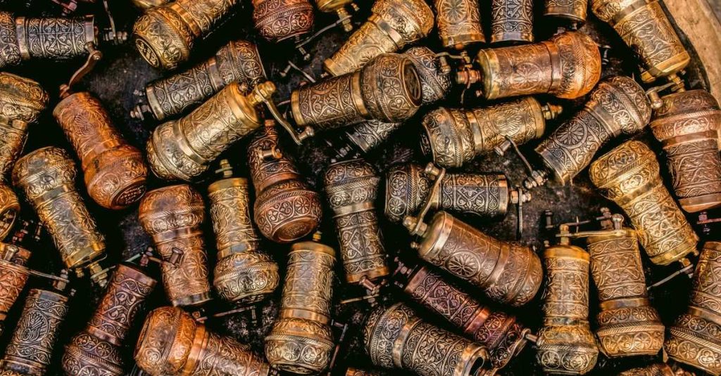 Overhead view of antique brass pepper grinders with ornate designs, captured in Ankara.