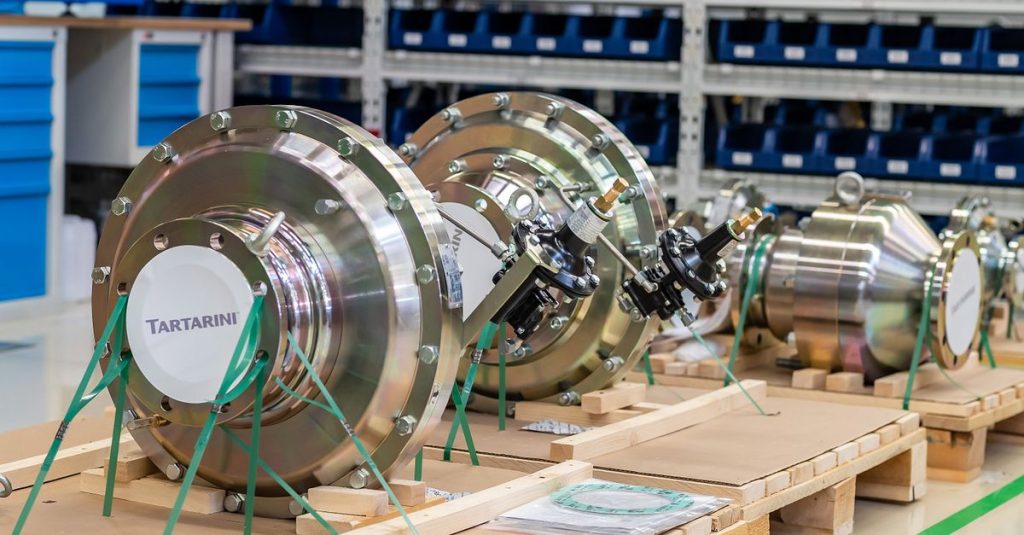 Large industrial valves stored in an organized workshop environment.