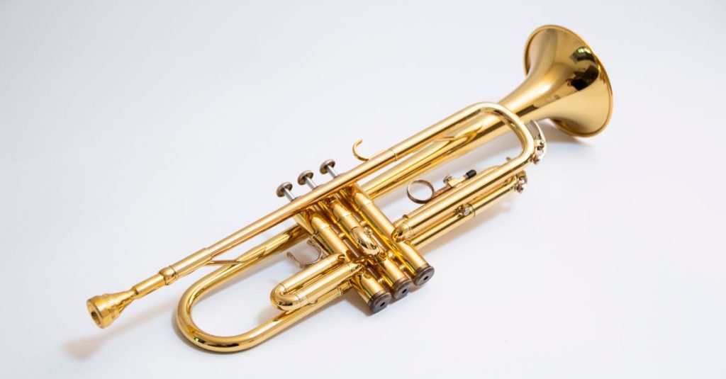 Close-up of a shiny gold trumpet isolated on a white background.