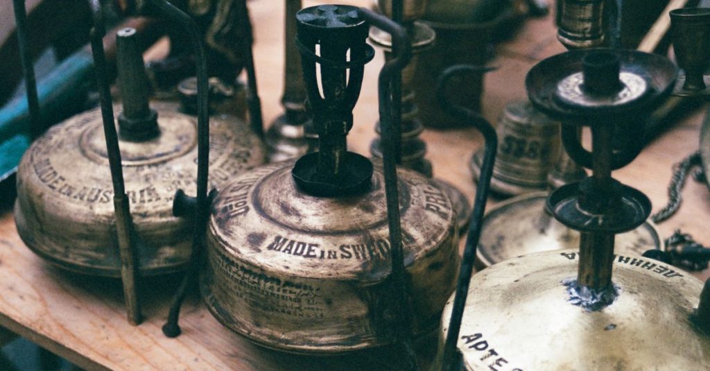 Close-up of vintage Primus stoves on display with intricate engravings, showcasing retro design.