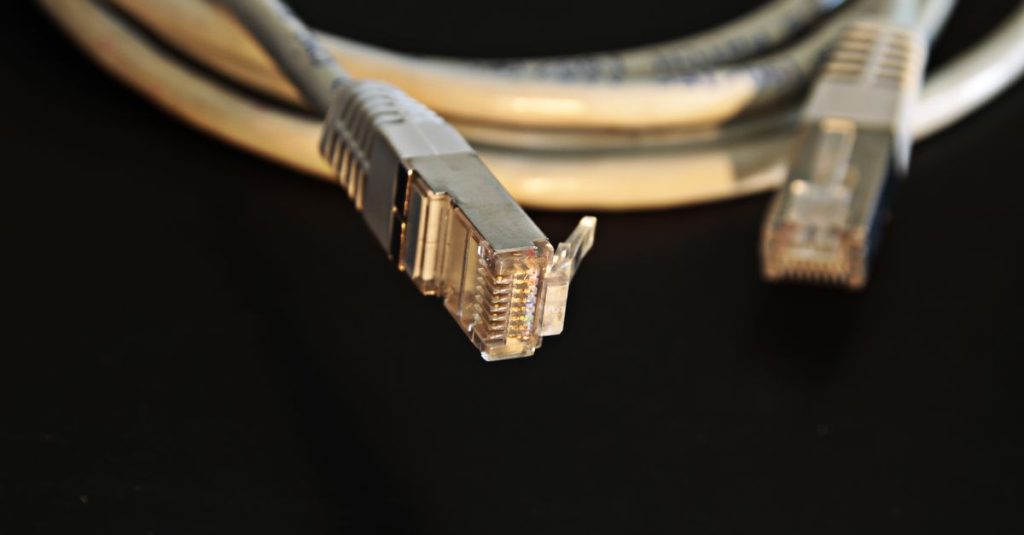 Detailed close-up of a network Ethernet cable showing connectors on a black background.