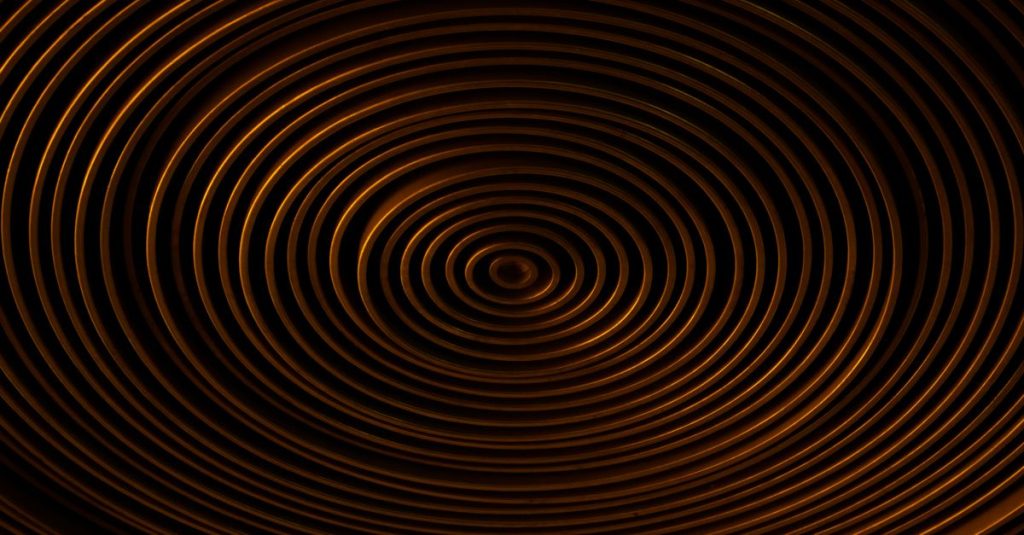 Concentric copper spirals on a dark background create a captivating abstract pattern.