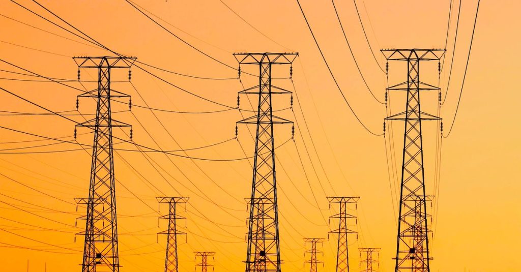 Silhouetted power lines against a vibrant orange sunset, symbolizing energy and infrastructure.