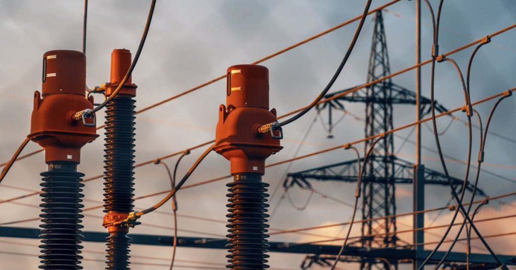 Detailed view of power transformers and lines against a sunset sky in Austria.