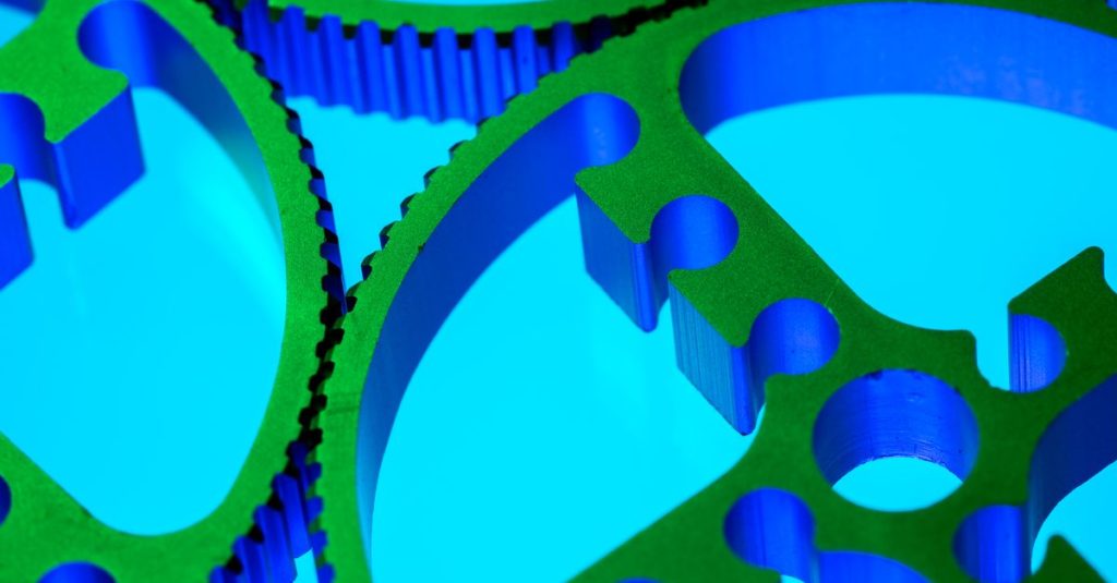 Close-up of colorful metallic gears in vibrant lighting, showcasing precision engineering and innovation.