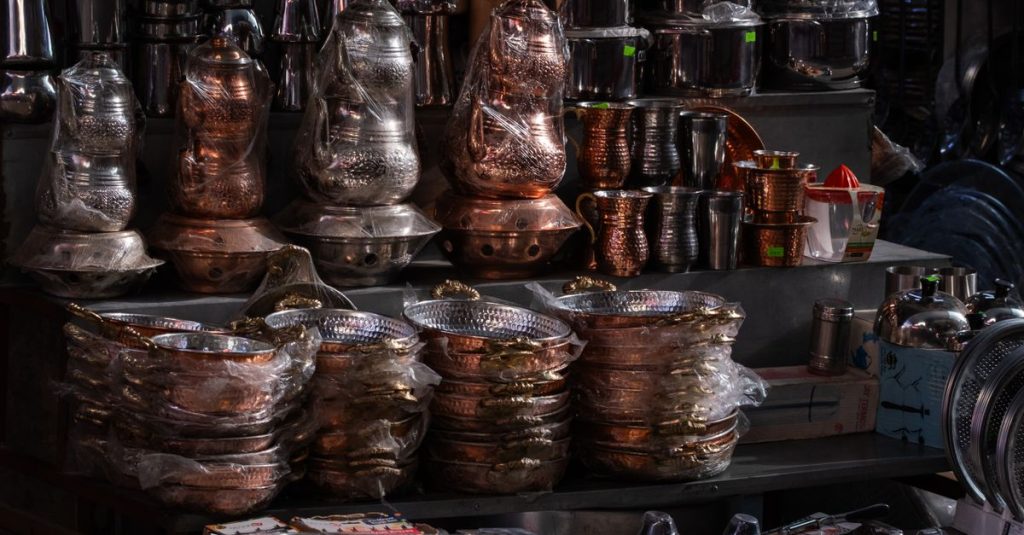 A vibrant display of traditional copper and metalware at a market stall in İzmir, Türkiye.