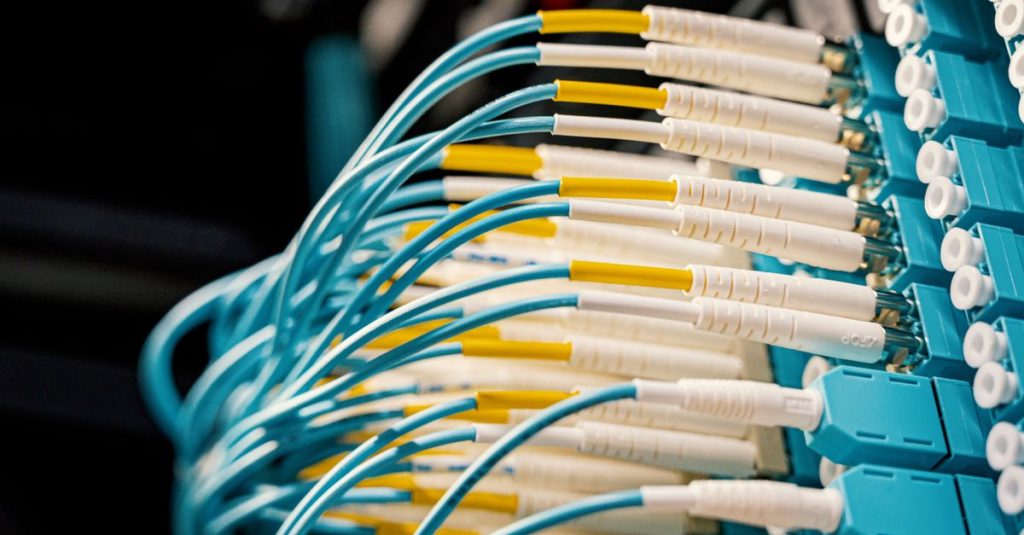 High angle of fiber optical switch with connected cables in modern server room