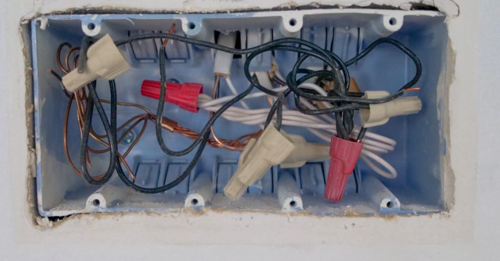 Detailed view of an opened electrical switchboard with visible wires and connectors.