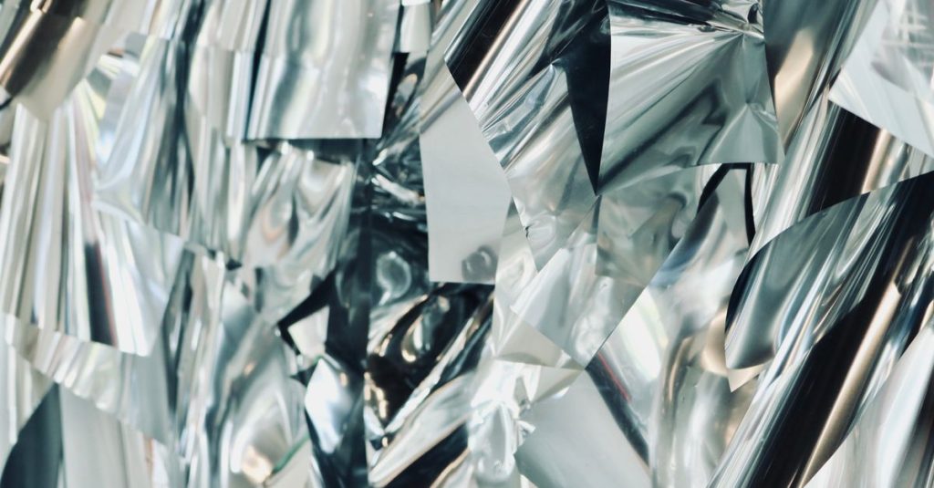 Close-up view of a shiny, abstract metallic surface with a textured background.