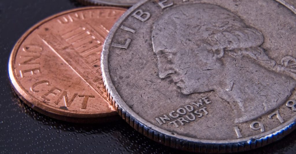 Detailed close-up of a US quarter and penny highlighting currency texture.