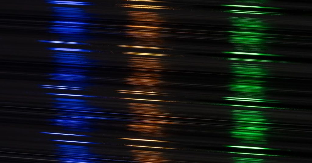 Colorful neon light streaks in abstract motion against a dark backdrop.