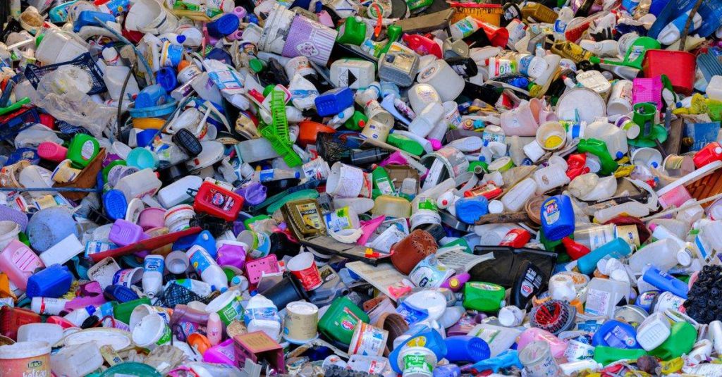 Massive colorful collection of used plastic bottles and containers in a recycling center.