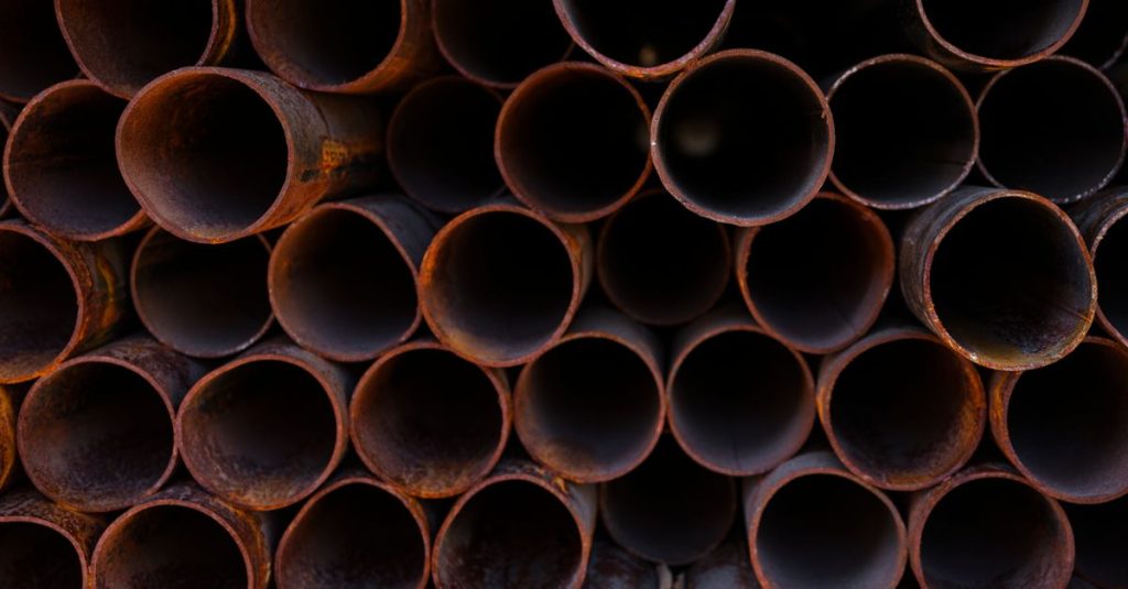 Close-up view of stacked rusty industrial pipes, showcasing their texture and corrosion.