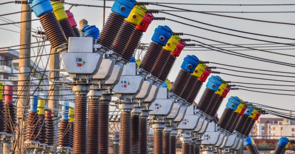 Multiple colorful electrical transformers at an outdoor power station under the daylight.