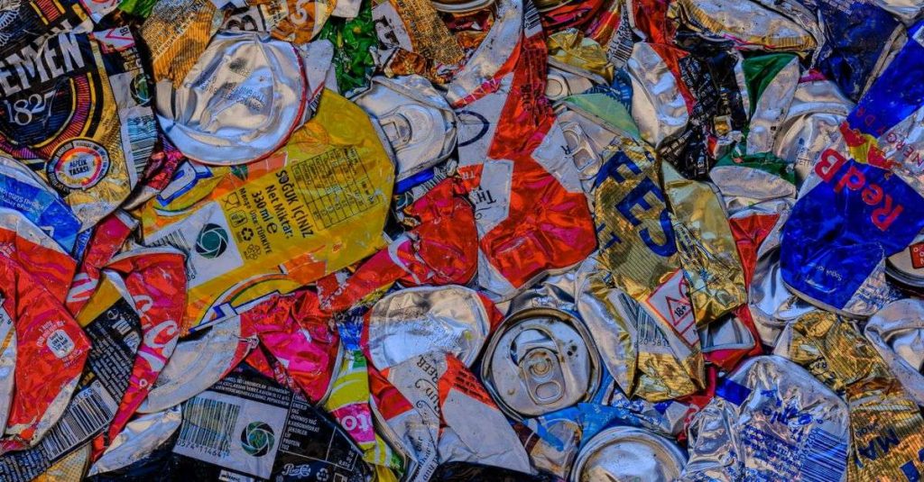 A vibrant display of crushed aluminum cans showcasing recycling art with a colorful pattern.