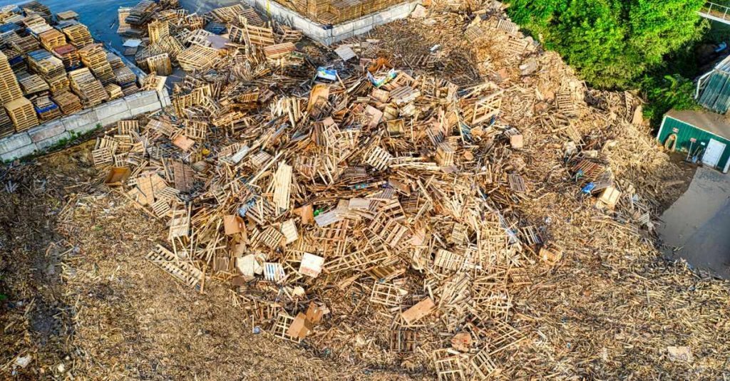 Aerial shot of wooden pallets stacked for recycling in an industrial yard.