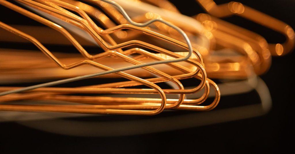 Close-up abstract composition of overlapping wire clothes hangers in warm lighting.