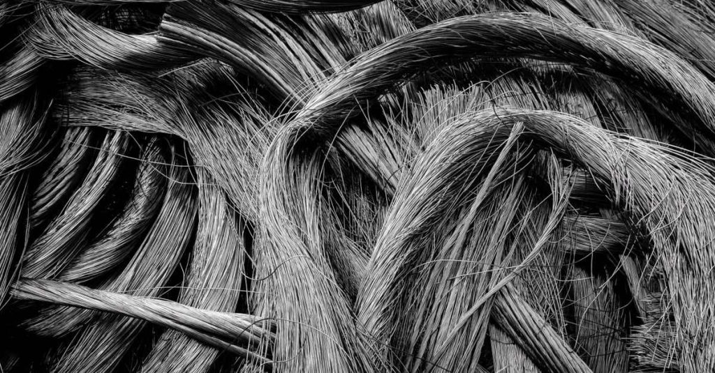 Intricate black-and-white close-up of intertwined metal wires showcasing industrial textures.