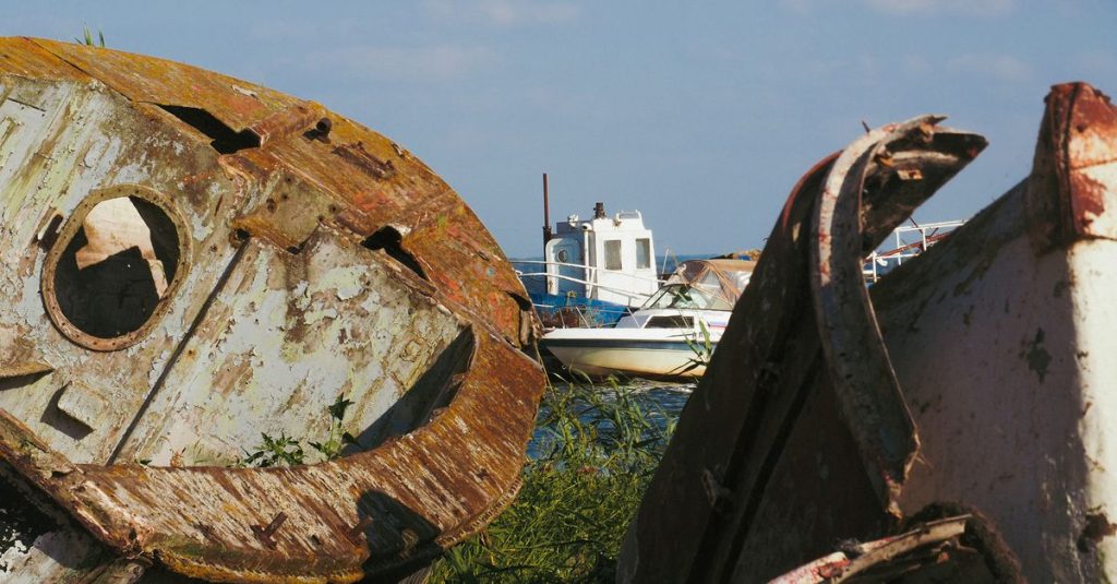 Rusty boats decay by the sea in Kaliningrad Oblast, Russia, showcasing urban exploration beauty.