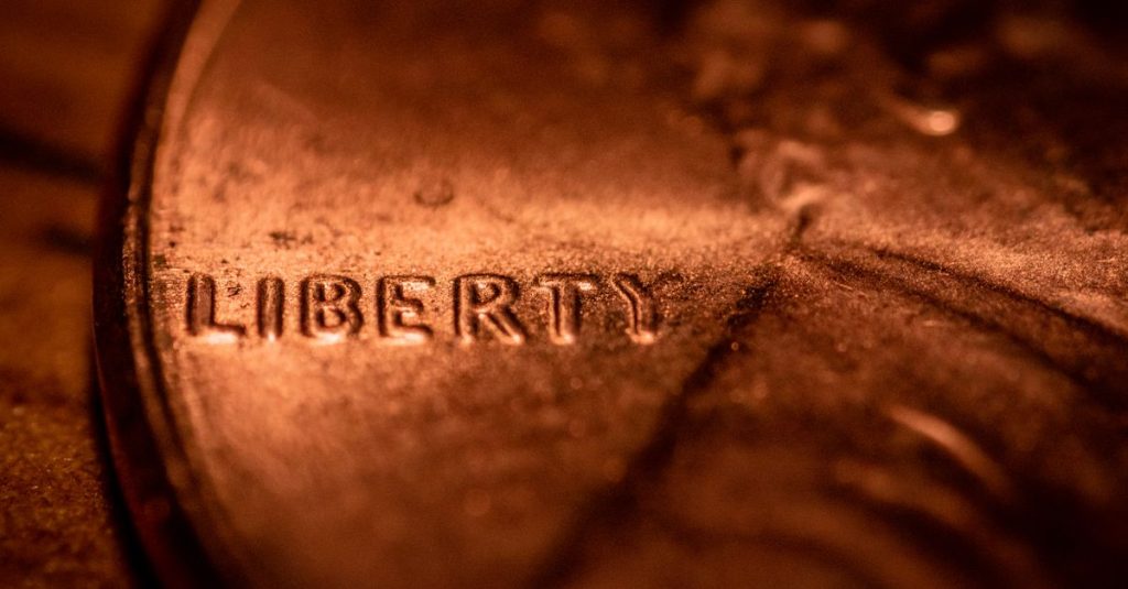 From above closeup of silver cent with liberty word and profile of Lincoln president of USA on surface of coin on table