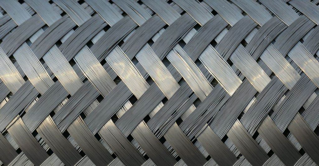 Detailed view of a metallic mesh with interwoven strands, showcasing industrial design and texture.