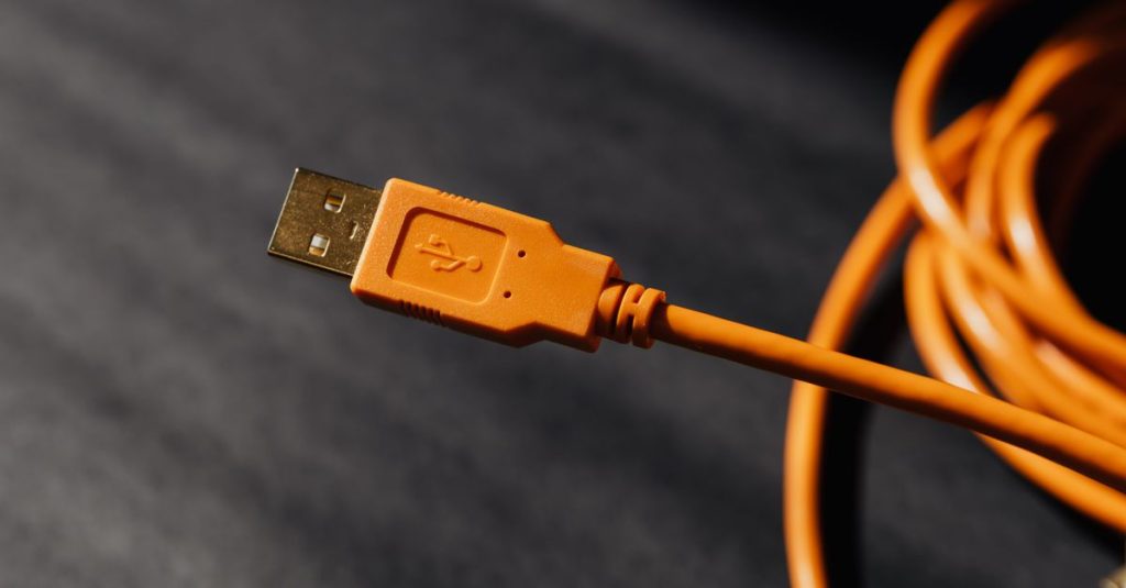 Detailed macro photo of an orange USB cable connector with focus on texture.