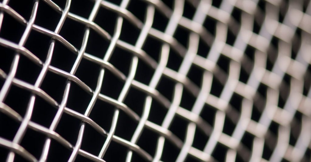 Detailed close-up of metal wire mesh pattern with a blurred background, showcasing texture and structure.