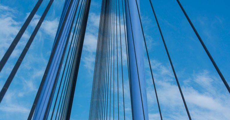 Close-up of Erasmus Bridge cables in Rotterdam, showcasing modern architecture against a clear sky.