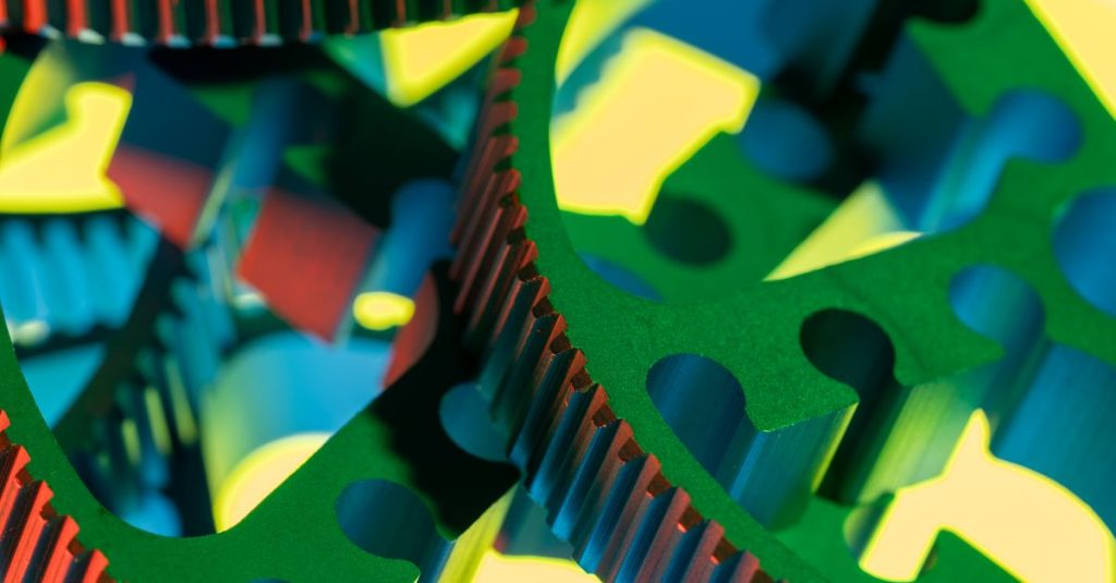 Vibrant macro photograph of interlocking colorful gears, showcasing technology and engineering precision.