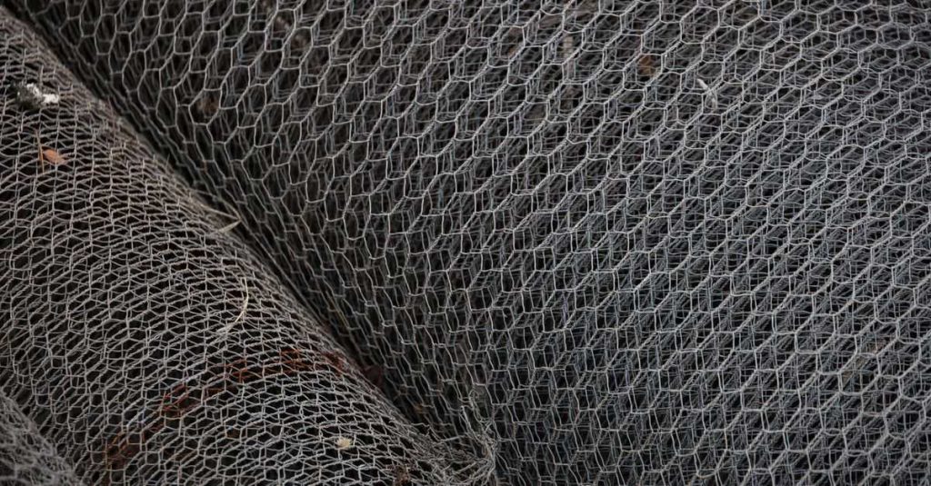 Detailed view of rolled metal wire mesh showcasing intricate patterns, ideal for industrial and construction themes.