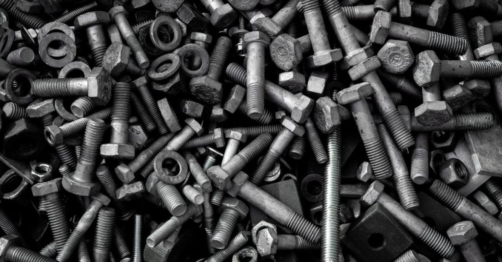 Detailed image of assorted industrial bolts and screws for recycling or mechanics.