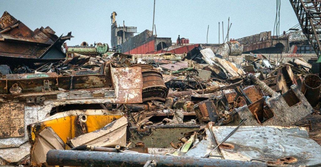 Metal rusty worn out constructions with cargo crane on dump in neglected area