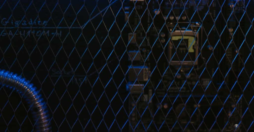 Artistic view of a circuit board through metal mesh with blue lighting.