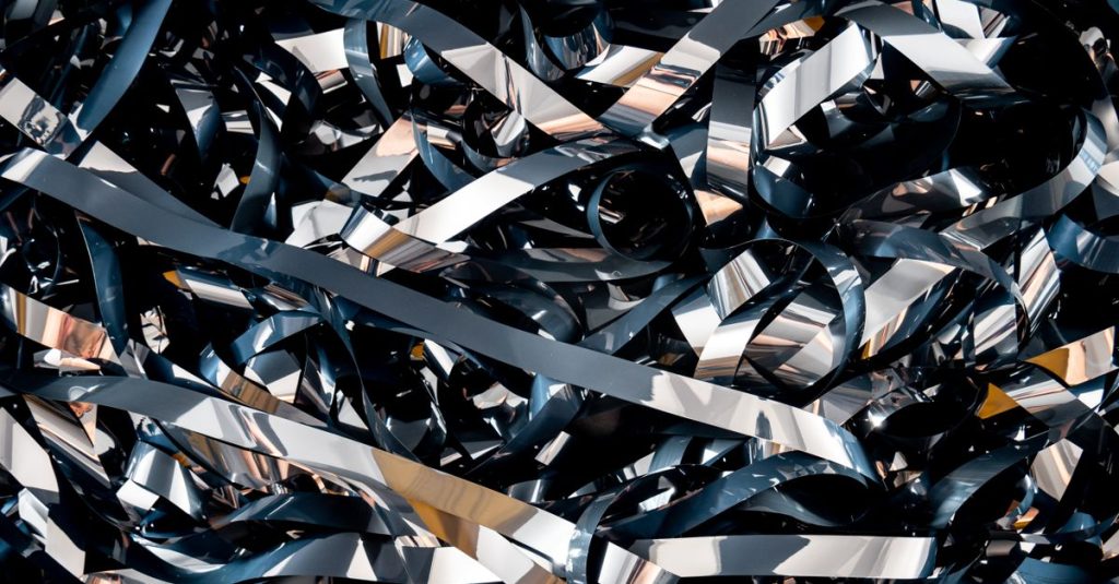 A detailed close-up of tangled magnetic tape ribbons creating a complex abstract pattern.