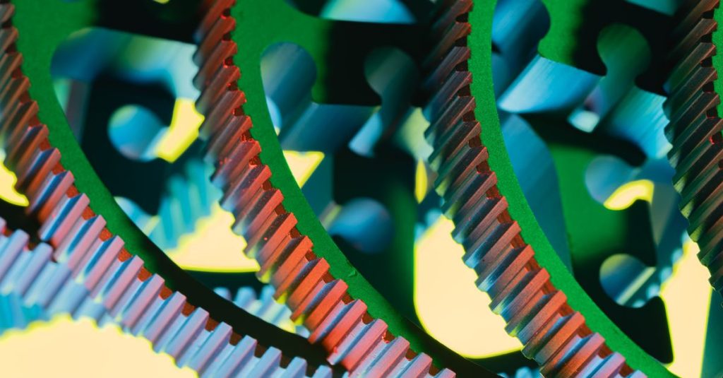 Tercan Hurdacı Vibrant macro shot of multicolored gears interlocking in an abstract industrial design.