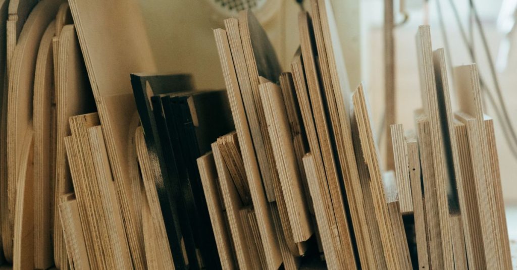 A collection of variously sized wooden planks neatly arranged in a workshop environment.